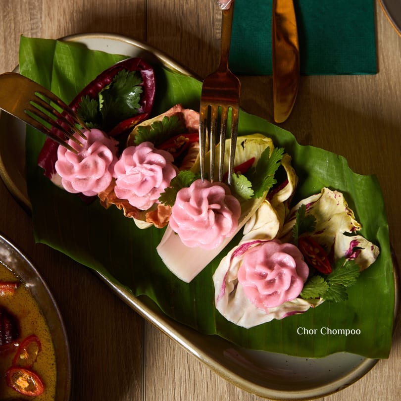 Khaosan's Chor Chompoo, pink flower-shaped dumplings on banana leaves with chili and herbs.