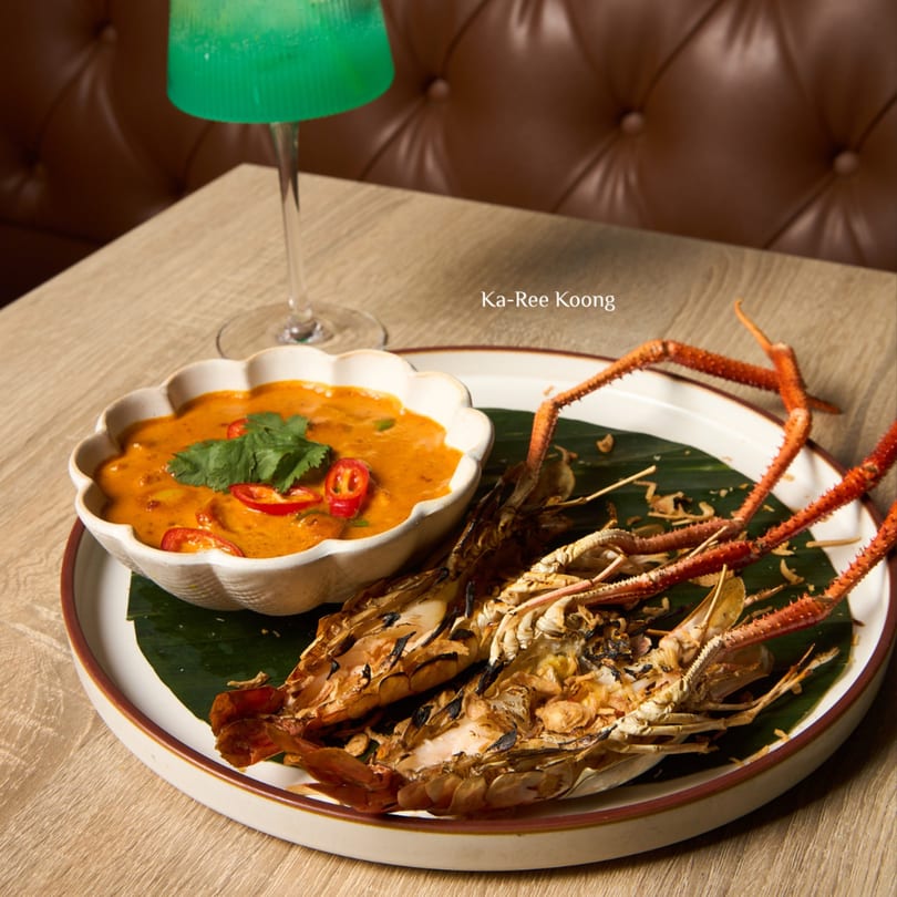 Grilled river prawns with a side of Ka-Ree Koong curry, garnished with chili and cilantro.
